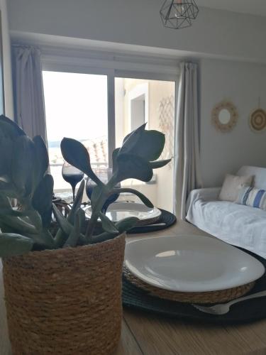 a living room with a table and a potted plant at Asterias blue Studio in Ermioni