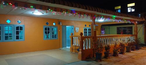a building with christmas lights and potted plants at Homestay Damai Sri Kota in Kepala Batas