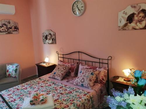 a bedroom with a bed and a clock on the wall at Portico Montiferru in Scano Montiferro