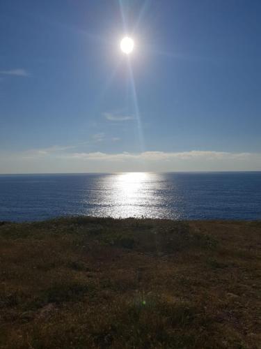 a view of the ocean with the sun in the sky at Portico Montiferru in Scano Montiferro