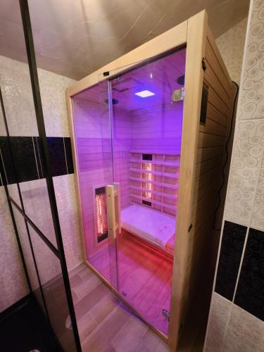 a glass shower with purple lights in a room at Kuća za odmor Kleopatra in Netretić