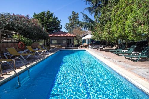 - une piscine avec des chaises et un kiosque dans l'établissement Catalunya Casas An oasis for up to 26 nature loving guests!, à Sils