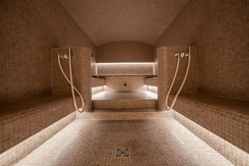 a tiled bathroom with a shower with at Sport Club Residences & Spa in Crans-Montana