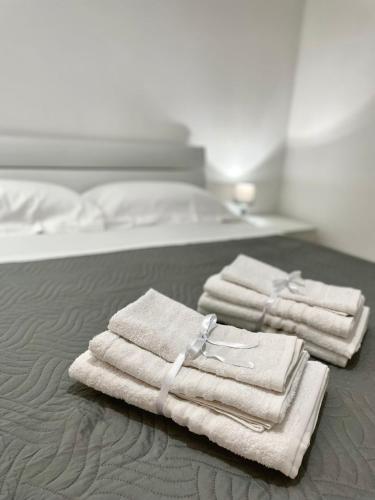 three towels sitting on top of a bed at L'atelier - Locazione turistica in Scilla