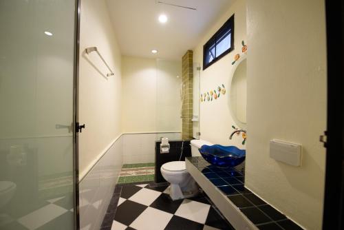 a bathroom with a toilet and a glass shower at Chanaplace Lanna in Chiang Mai