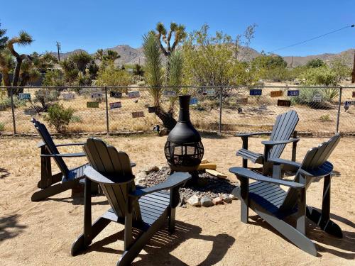 un gruppo di sedie seduti accanto a un focolare di Float Pool, Hot Tub, Sauna, Firepit, BBQ, Telescope, Views, EV Chg, a Joshua Tree