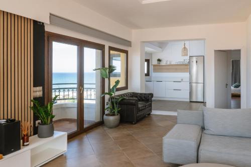 a living room with a couch and a view of the ocean at Mare Apartment Costal Gem in Gázion