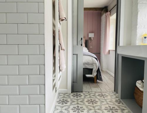 a bathroom with a fireplace and a room with a bed at The Hayloft in Crewe