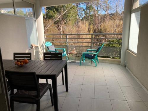 un porche avec une table et des chaises sur un balcon dans l'établissement Appart'Calvi, 200 m de la plage de la Pinède, WIFI gratuit, à Calvi