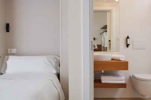 a bedroom with a bed and a sink and a mirror at Hotel Trina 20 in Palas de Rei 