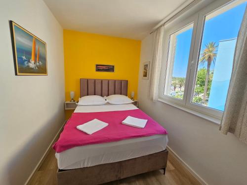 sypialnia z dużym łóżkiem i różowym kocem w obiekcie Apartment Riva w Makarskiej