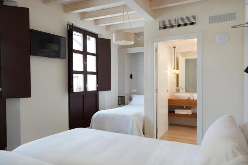 a hotel room with two beds and a bathroom at Hotel Trina 20 in Palas de Rei
