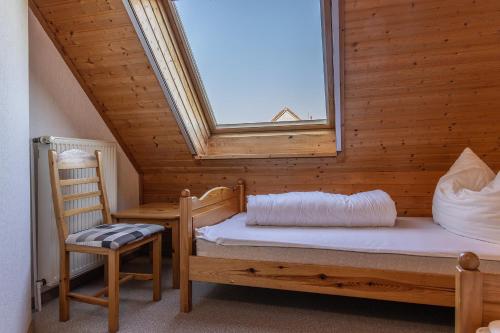 um quarto com uma cama, uma janela e uma cadeira em 50085... em Harlesiel