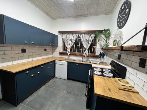 a kitchen with blue cabinets and a wooden counter top at Seaview Family Cottage in Swakopmund