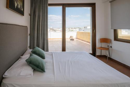 a bedroom with a bed with a view of a balcony at Mare Apartment Costal Gem in Gázion