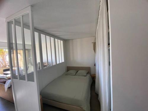 une petite chambre avec un lit et une fenêtre dans l'établissement Cosy appart lumineux avec grande terrasse, à Martigues