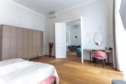 a bedroom with a bed and a desk with a pink chair at Long Term Rentals in Vienna