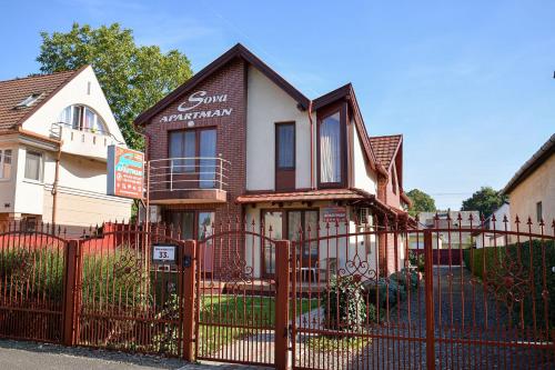 a house with a fence in front of it at SovaApartman in Hajdúszoboszló