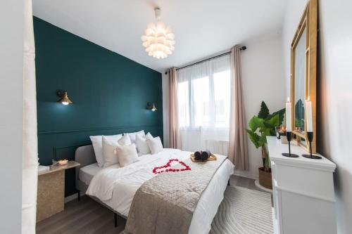 une chambre avec un lit blanc avec un mur vert dans l'établissement Relax et Cocooning - Maison de ville Tours - Proche gare, à Tours