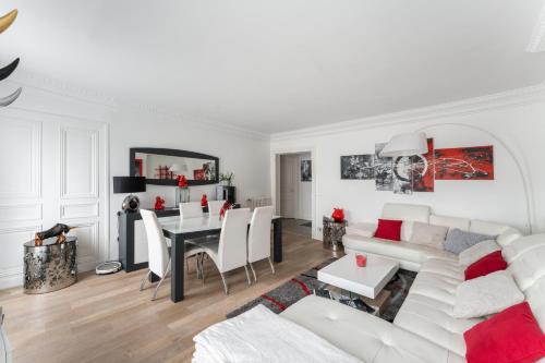 un salon blanc avec un canapé blanc et une table dans l'établissement Appartement Haussmannien - dernier étage, à Paris