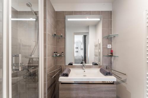 une salle de bain avec un lavabo et une douche dans l'établissement Appartement Haussmannien - dernier étage, à Paris