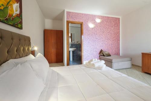 a bedroom with a large white bed and a bathroom at Bed&Belvedere in Otranto