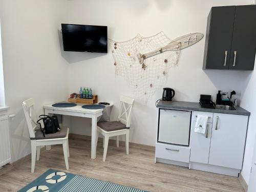 eine Küche mit einem Tisch und einem kleinen Tisch mit Stühlen in der Unterkunft Apartamenty Via Mare in Ustka
