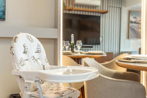a white high chair sitting in a dining room at DELUX PRAIA Flats in Natal