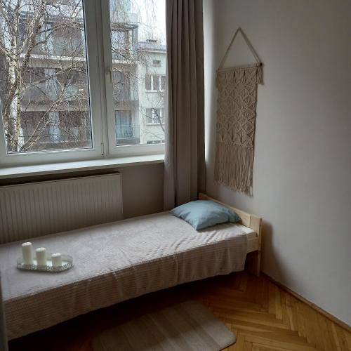 a small bed in a room with a window at Regem Pokoje Złota in Warsaw