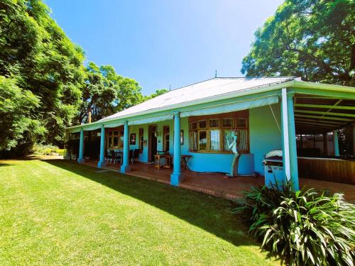 a blue house with a porch and a yard at Bonnie Highlands in Ladysmith