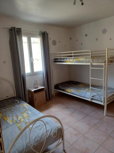een slaapkamer met 2 stapelbedden en een raam bij le soleil du verdon in Baudinard