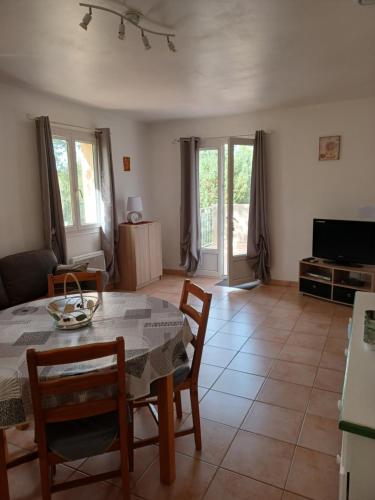 - un salon avec une table, des chaises et une télévision dans l'établissement le soleil du verdon, à Baudinard