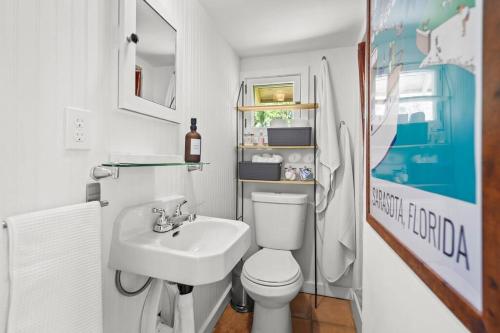 a bathroom with a white toilet and a sink at The Julia Place Carriage House in Sarasota