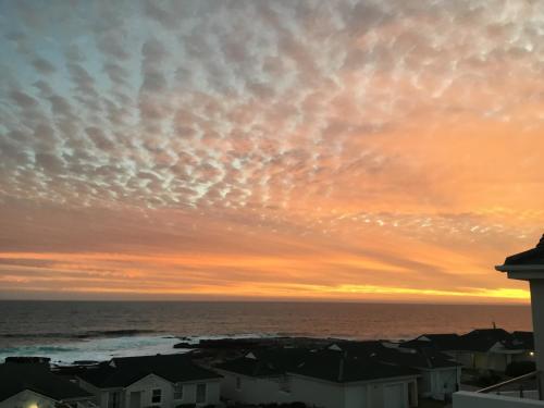 a sunset over the ocean with clouds at 43 WHALE ROCK ESTATE in Hermanus