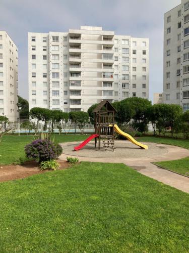 ラ・セレナにあるDepartamento Edificio Terrazas de Solの高層ビルが立ち並ぶ公園にある滑り台のある遊び場