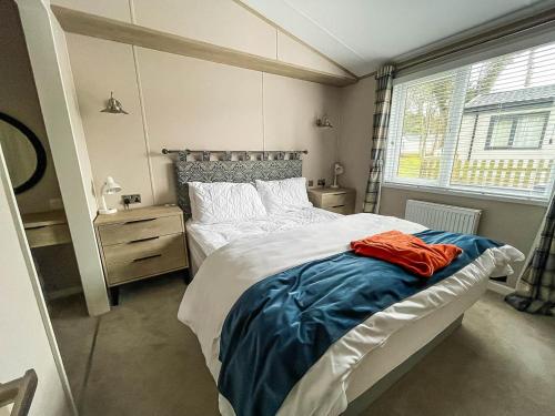 ein Schlafzimmer mit einem großen Bett und einem Fenster in der Unterkunft Beautiful Lodge With Decking At Azure Seas In Suffolk, Sleeps 6 Ref 32217og in Lowestoft