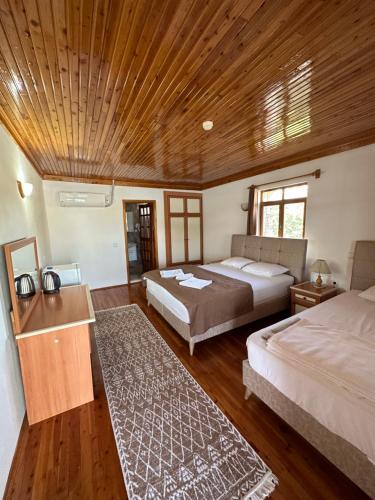 una camera con 2 letti e un soffitto in legno di Kekova Pansiyon a Demre