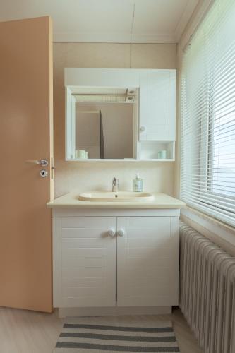 a bathroom with a sink and a mirror at Serenity by the Sea / 3-BR House / Sea View in Syðrugøta