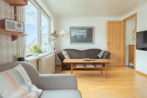 - un salon avec un canapé et une table basse dans l'établissement Serenity by the Sea / 3-BR House / Sea View, à Syðrugøta