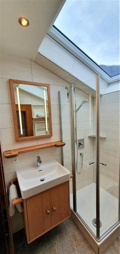 a bathroom with a sink and a shower with a mirror at Gästehaus Hanauerbichl in Schönau am Königssee