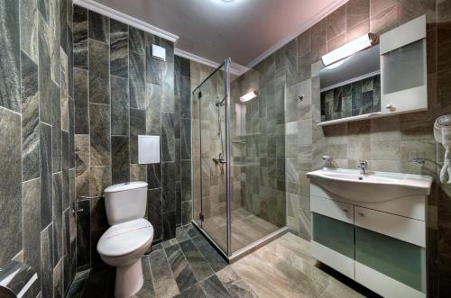 a bathroom with a toilet and a sink and a shower at Hotel Kokiche in Sunny Beach