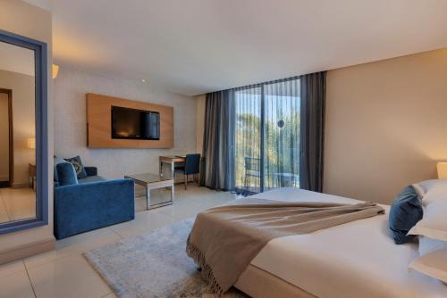 a hotel room with a bed and a large window at Herbert Samuel The Reef Eilat in Eilat