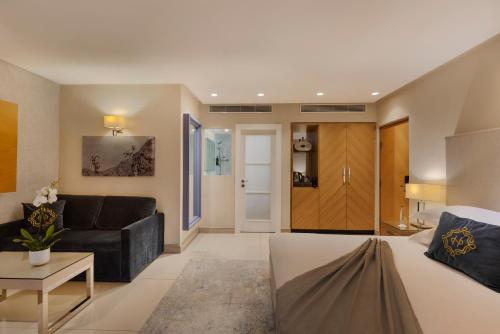a living room with a bed and a couch at Herbert Samuel The Reef Eilat in Eilat
