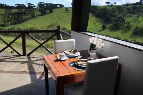 a table and chairs with a table and a window at Estalagem Sensações in Cunha