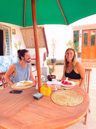 a man and woman sitting at a table under an umbrella at Penida Hills in Nusa Penida