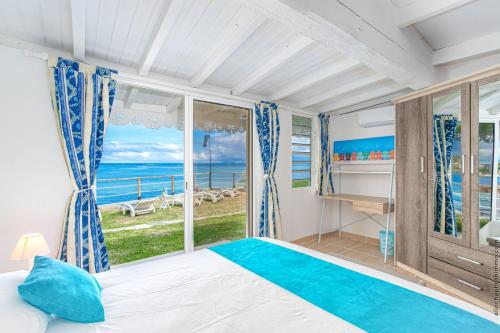 Un dormitorio con una cama y vista al mar. en Villa Pointe Chaudière, en Le Vauclin