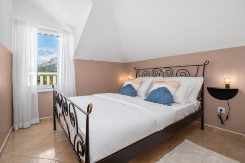 sypialnia z dużym łóżkiem i oknem w obiekcie Villa Lux w mieście Promajna