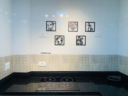 La salle de bains est pourvue d'un mur carrelé avec des photos. dans l'établissement Premium RJ - Consulado, à Rio de Janeiro