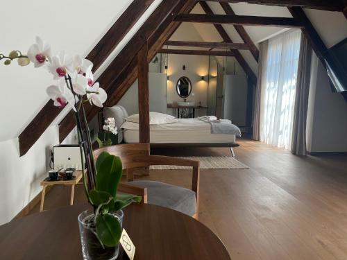 a bedroom with a bed and a table with flowers at Casa Albert Boutique & Restaurant in Braşov