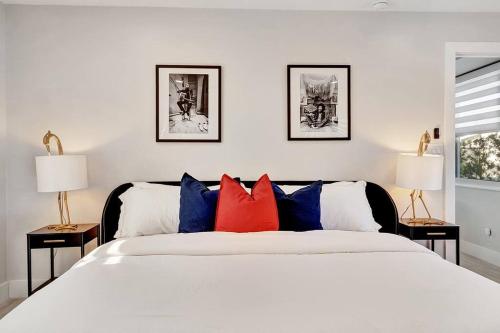 Un dormitorio con una cama blanca con almohadas rojas y azules en Oceana @ Casa Del Sol en Fort Lauderdale